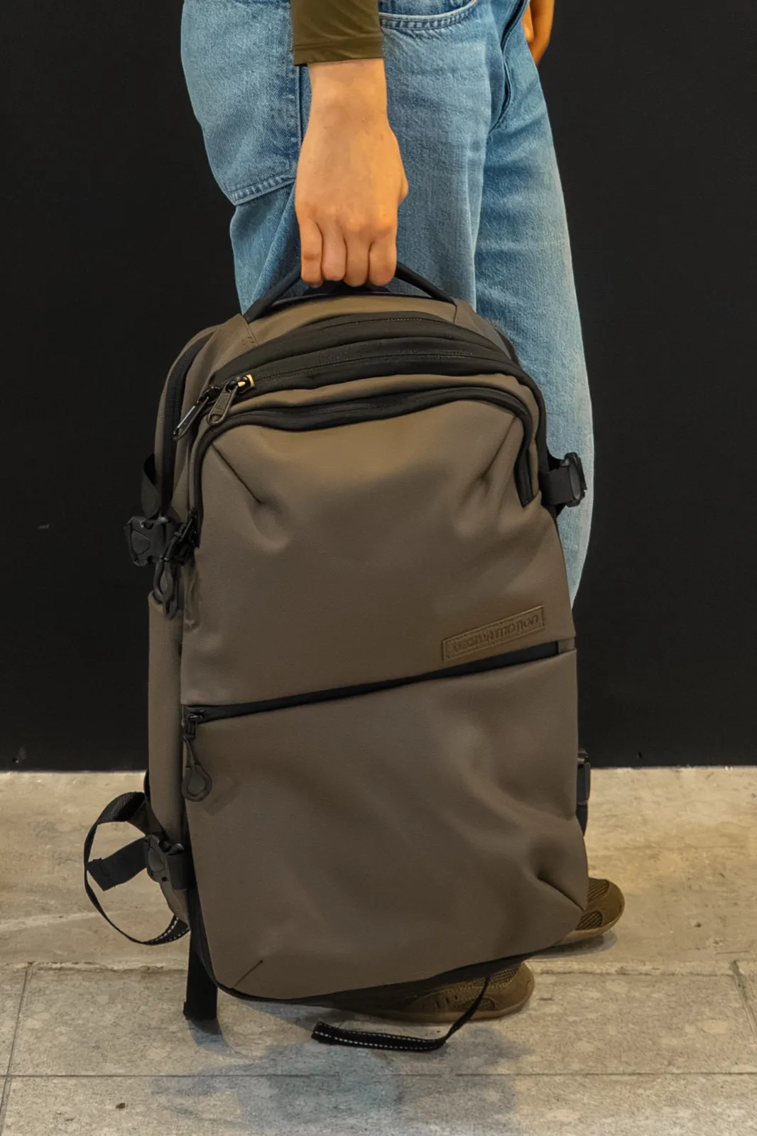 Photo of the Looma Motion backpack as the client sent it, held against a wall